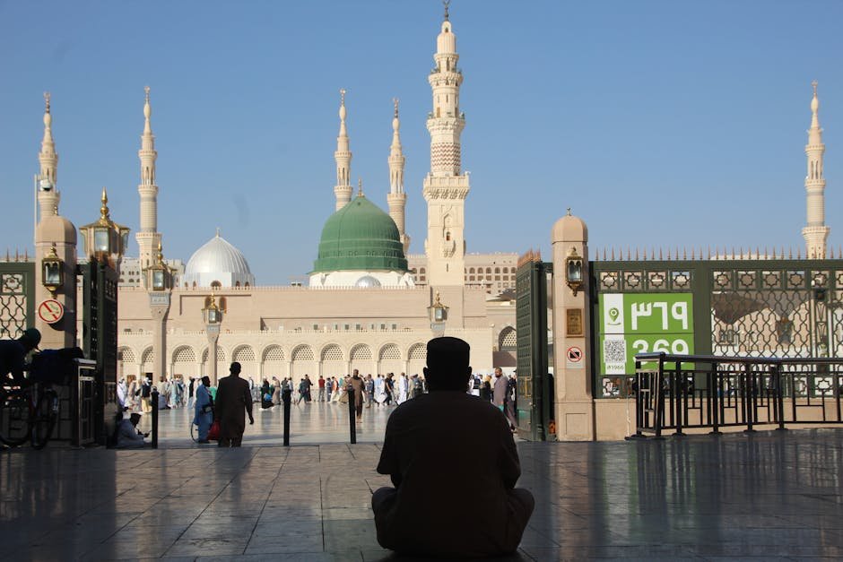 Silhouette of a person sitting in front of Al-Masjid an-Nabawi in Madinah, Saudi Arabia.